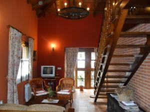 una sala de estar con paredes de color naranja y una escalera. en Apartamentos Rurales Los Villares, en Colunga