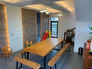 jadalnia z drewnianym stołem i ławkami w obiekcie 嘉的家 w mieście Zhuangwei
