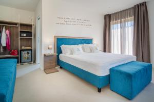 1 dormitorio con 1 cama grande y cabecero azul en Do' Petro Relax & Pool, en Vico Equense