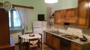 a kitchen with wooden cabinets and a table and a kitchen with a sink at Casa Rosa in Montella