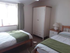 um quarto com 2 camas, um armário e uma janela em Wren Cottage em Louth