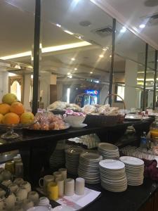 a kitchen with plates and food on a table at Platinum Hotel in Soûr