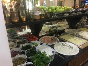 a buffet with plates of food and fruits and vegetables at Platinum Hotel in So&ucirc;r