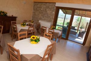 un restaurante con mesas y sillas con flores. en Agriturismo Il Vecchio Pollaio, en Castel di Sangro