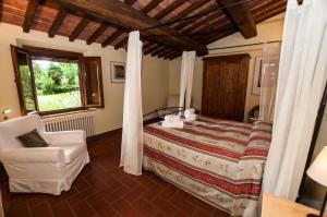 een slaapkamer met een bed en een stoel bij I Gelsi in Figline Valdarno