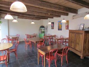 a restaurant with wooden tables and red chairs at Le Relais de la Tour in Figeac