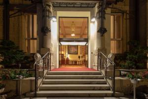 schody prowadzące do budynku z czerwonym dywanem w obiekcie Palace Grand Hotel Varese w mieście Varese