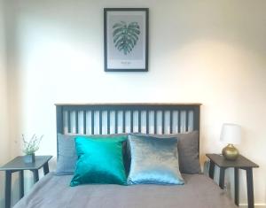 uma cama com almofadas azuis num quarto com duas mesas em Large 2B2B Near Southern Cross FreeParking GYM POOL em Melbourne