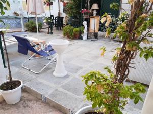 een patio met een tafel en stoelen en potplanten bij Villino Angela A Sant'Anna in Boscotrecase