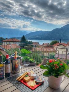 トレメッツォにあるApartment Theresaのバルコニーのテーブルにチーズとワインのトレイ