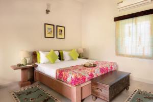 ジョードプルにあるKot Dunara Jodhpurのベッドルーム1室(ベッド1台、テーブル、窓付)