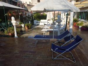 een groep stoelen en een parasol op een patio bij Villino Angela A Sant'Anna in Boscotrecase