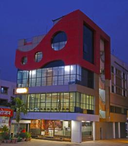 a tall red building with a red at Hotel Sai Country Inn by Shantikamal in Shirdi