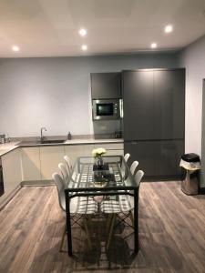 a kitchen with a glass table and white chairs at reflections luxury modern accommodation in Saint Monance