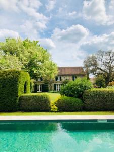 une maison avec une piscine en face d'une cour dans l'établissement La Marcotte - Pierres d'Histoire, à Saint-Martin-en-Bière