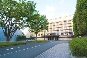 a large building with a tree in front of it at Kyoto Brighton Hotel in Kyoto