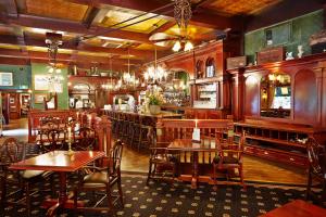 a restaurant with wooden tables and chairs and a bar at Hotel Mastbosch Breda in Breda