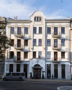 a white building with a van parked in front of it at Hotel Wieniawski in Lublin