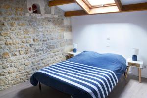 una camera con un letto con un muro di mattoni di au pied de l'Ile Oléron a Bourcefranc