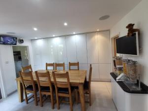 a dining room with a wooden table and chairs at Chart House Bed and Breakfast in Dorking