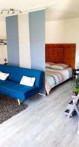 a living room with a blue couch and a bed at Appartement 50m du Lac in Gérardmer