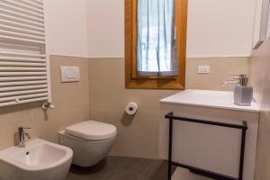 a bathroom with a toilet and a sink and a mirror at Appartamento Sonelia in Polcenigo