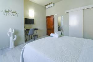 Habitación blanca con cama grande y escritorio. en B&B Ulivo Gaio en San Miniato