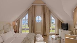 a bedroom with a bed and a large window at Precise Resort Schwielowsee in Werder