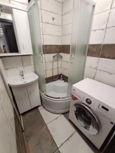 małą łazienkę z pralką i umywalką w obiekcie Дешеві кімнати біля парку w Iwano-Frankiwsku