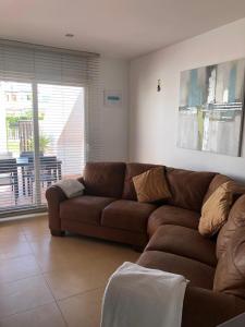 a brown couch in a living room with a window at Condado de Alhama in Alhama de Murcia