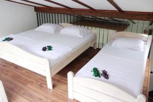 two beds in a room with white sheets and christmas decorations at House Legacy in Bihać