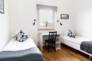 sypialnia z 2 łóżkami, biurkiem i oknem w obiekcie Brink Hotell w mieście Eslöv