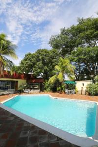 ein großer blauer Pool mit Bäumen im Hintergrund in der Unterkunft Hotel Estrella in Managua