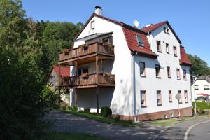 un edificio bianco con un balcone su una strada di Moderne und sehr gemütliche Ferienwohnung a Wattenbach