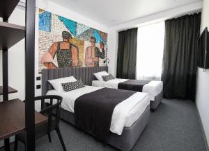 a hotel room with two beds and a mural at SV Hotel in Vladivostok