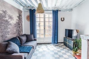 uma sala de estar com um sofá e uma janela em Carpe Diem em Tourrettes-sur-Loup