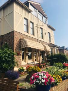 ein großes Haus mit Blumen davor in der Unterkunft The Bebington in Bebington