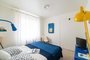 a bedroom with a bed and a yellow lamp at Le Studio Bleu de la gare in Vieux-Boucau-les-Bains