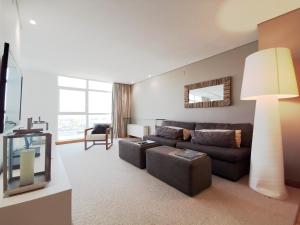 a living room with a couch and a television at Parque Nacoes Prime Apartments in Lisbon