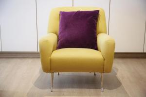 einen gelben Stuhl mit lila Kissen in einem Zimmer in der Unterkunft B&B Tempelhof in Gent