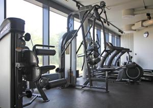 a gym with several tread machines in a room at HOOM Home & Hotel Järfälla in Järfälla