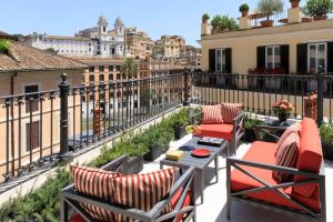 a balcony with chairs and a table with a view of the city at Rocco Forte House Piazza Di Spagna, Rome in Rome