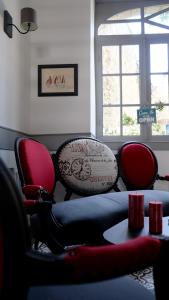 een woonkamer met rode stoelen en een bank bij La Glycinière Chambres d'Hôtes in Pont-Croix