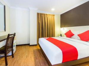 um quarto de hotel com uma cama grande e uma cadeira em OYO 431 Hotel De Grand Orchard em Kuala Lumpur