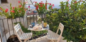 einen Tisch und Stühle auf einem Balkon mit Blumen in der Unterkunft Casa Margò in Monreale