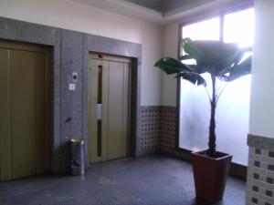 um corredor com um vaso de plantas num edifício em Alto Estilo Barra Posto 8 no Rio de Janeiro
