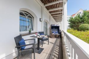 a patio with chairs and a table on a porch at Strandhaus Belvedere in Binz