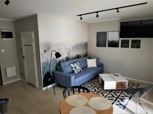 巴爾托希采的住宿－Apartament Limanowskiego 20/6，客厅配有蓝色的沙发和桌子