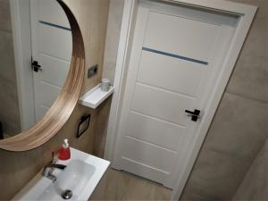 a bathroom with a sink and a mirror at Apartament Limanowskiego 20/6 in Bartoszyce