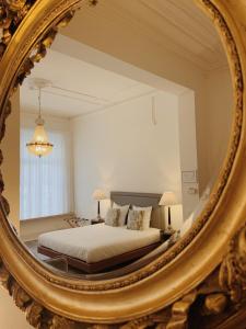 a bedroom with a bed and a mirror at La Lys Rooms & Suites in Ghent